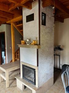 a stone fireplace in a living room with a table at Domek Sabrinka in Słajszewo