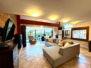 ein Wohnzimmer mit Sofa und Fernseher in der Unterkunft Villa Pineta Grande in Lignano Sabbiadoro