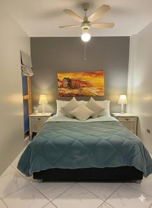 ein Schlafzimmer mit einem Bett und einem Gemälde an der Wand in der Unterkunft Tides Lobitos in Lobitos