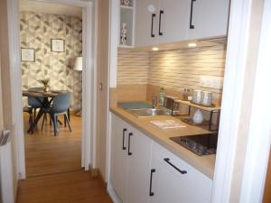 una cucina con lavandino e tavolo in una stanza di Au gré des marées, 1 chambre a Hanvec Altre 11 foto