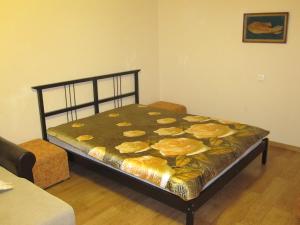 a bedroom with a bed with a flower blanket on it at Apartment Kropotkina 11a in Voronezh