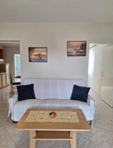 a living room with a white couch and a coffee table at Apartments Villa Granda Tolic in Biograd na Moru