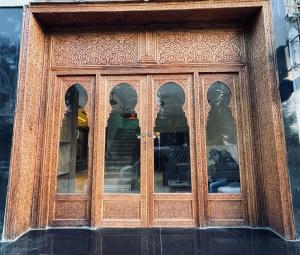 a wooden door with many windows on a building at Hôtel kairouan in Fez