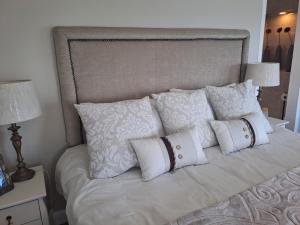 a white bed with white pillows on it at Boutique Inn - Serenity in Gordonʼs Bay