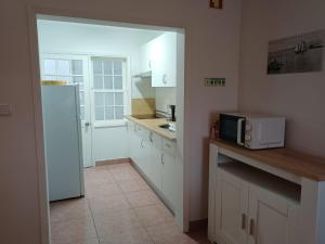 a kitchen with white cabinets and a white refrigerator at SEASTAR nº38 in Horta