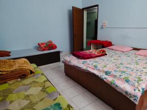 a bedroom with two beds and a mirror at Swaroop Ashray Homestay in Siliguri