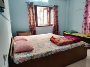un letto con due cuscini sopra in una stanza di Swaroop Ashray Homestay a Siliguri
