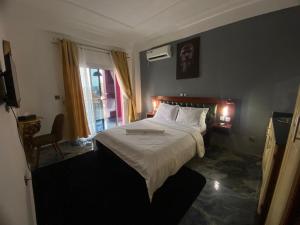 a bedroom with a large bed and a window at Hotel Saphir Group in Douala +69 photos