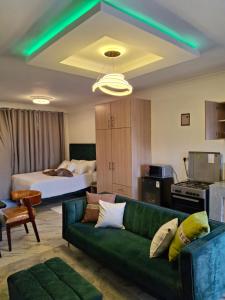 a living room with a green couch and a bed at Unique Comfort Stay in Nanyuki