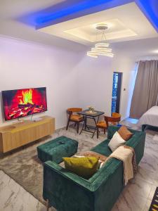 a living room with a couch and a tv at Unique Comfort Stay in Nanyuki