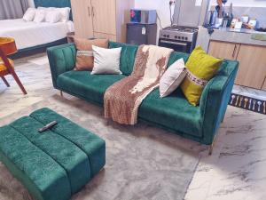 a green couch with pillows on it in a living room at Unique Comfort Stay in Nanyuki