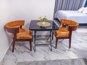 a room with a table and two chairs and a bed at Unique Comfort Stay in Nanyuki