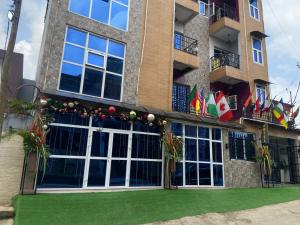 a building with a green lawn in front of it at Hotel Saphir Group in Douala