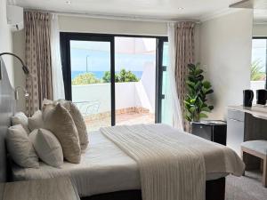 een slaapkamer met een bed met uitzicht op de oceaan bij St Helena Bay Hotel in St Helena Bay