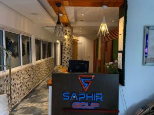 a restaurant with a saphir guru sign on a counter at Hotel Saphir Group in Douala