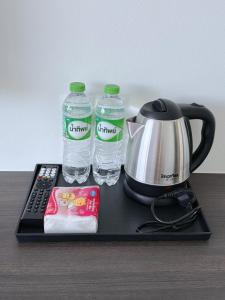 a tray with a coffee maker and two water bottles at A House Thalang เอ เฮ้าส์ ถลาง in Thalang