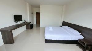 a bedroom with a bed and a television in it at A House Thalang เอ เฮ้าส์ ถลาง in Thalang