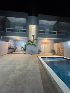 a large house with a swimming pool and a building at Casa beira Mar in Itanhaém