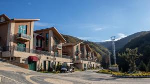 a row of buildings on a street in a mountain at Altındere Vadi Hotel in Akyazı