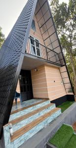 a house with a gambrel roof with stairs in front at Zerahs Private Pool Villa, Athirappilly - Extra upstair Bed space in Athirappilly +10 photos