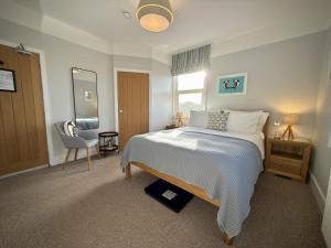 a bedroom with a bed and a chair and a mirror at The Ship Inn in Weybourne