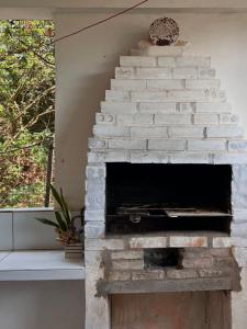 een stenen open haard in een woonkamer naast een raam bij Pousada Praia do Amor Pipa in Pipa
