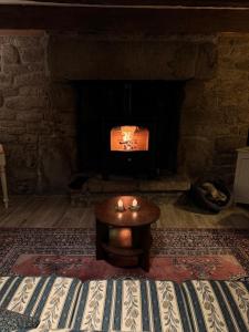een woonkamer met een open haard en een tafel ervoor bij Gîtes du Gohic - Le Cidre in Quistinic +35 foto's