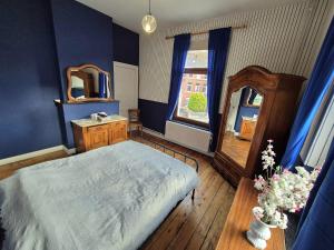 a bedroom with a large bed and a mirror at Maison de Maître in Liège