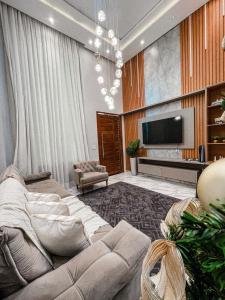 un soggiorno con divano e TV a schermo piatto di Life House Ubajara a Ubajara Altre 43 foto