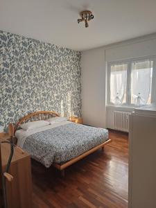 een slaapkamer met een bed in een kamer met behang bij B&B Il Melograno in Lomazzo