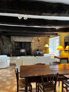 un soggiorno con tavolo e camino di Gîtes du Gohic a Quistinic
