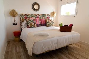 a bedroom with a large white bed and a window at Hostal Playa Pitaya in Torre del Mar