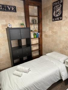 ein Schlafzimmer mit einem großen Bett und einer schwarzen Kommode in der Unterkunft Carmit Place in Haifa