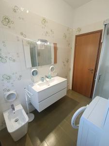 een badkamer met een wastafel, een toilet en een spiegel bij B&B Il Melograno in Lomazzo
