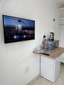 a tv hanging on a wall with a table at Seven on Cooper in East London