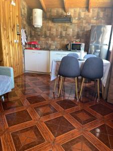 een keuken met een tafel en twee stoelen op een tegelvloer bij Cabañas Valentina in Valdivia