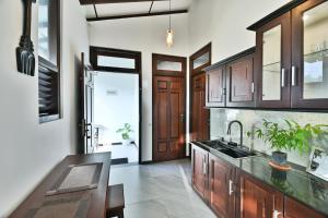 a kitchen with wooden cabinets and a sink at Mansion view in Unawatuna