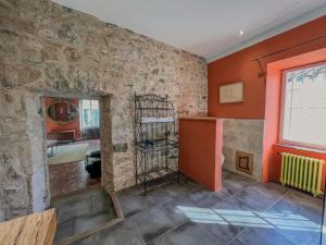 a room with a stone wall and a window at Hôtel d'Alibert in Caunes-Minervois