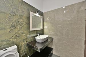 a bathroom with a sink and a toilet and a mirror at Mansion view in Unawatuna