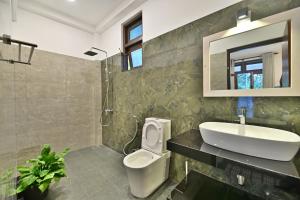 a bathroom with a sink and a toilet and a mirror at Mansion view in Unawatuna