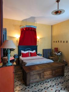 een slaapkamer met een bed met een rood gordijn bij Les Chambres des Dames in Rieux-Minervois