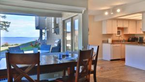 a kitchen and dining room with a table with a view at Beachfront Condo - Mutiny Bay by AvantStay Views in Freeland