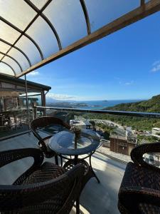 Ein Tisch und Stühle auf einem Balkon mit Aussicht in der Unterkunft 隱山居 海景包棟2-10人 in Jiufen