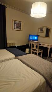 a hotel room with two beds and a desk with a laptop at Cosig house in Nygård