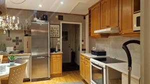 a kitchen with wooden cabinets and a stainless steel refrigerator at Cosig house in Nygård