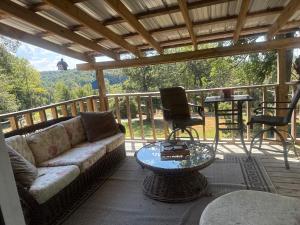 a living room with a couch and a chair on a porch at serenity hill in Brownsville