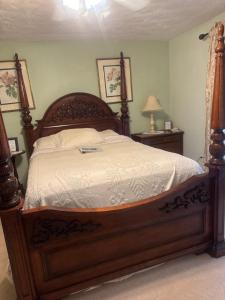 a bedroom with a large bed with a wooden frame at serenity hill in Brownsville