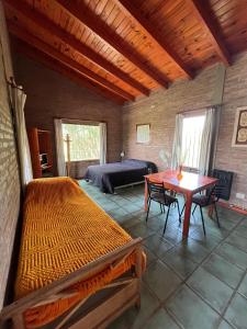a bedroom with a bed and a table and a bed and a desk at Los Cardones de Mayu in San Antonio de Arredondo