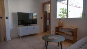 a living room with a couch and a television at Hostal Playa Pitaya in Torre del Mar