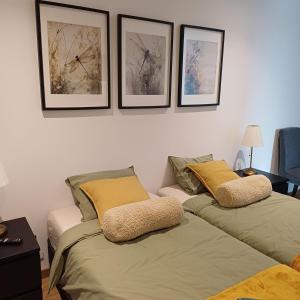 two beds in a room with pictures on the wall at Casa Terra das Vinhas in Esposende +22 photos